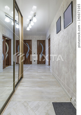 Spacious Apartment Entryway Interior with Mirror Wardrobe and Wooden Doors Spacious Apartment Entryway Interior with Mirror Wardrobe and Wooden Doors 140873165