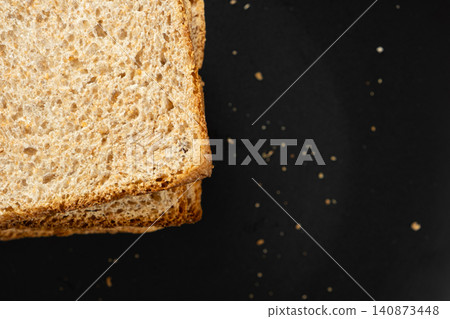 High angle view of crispy grain toast slices served for breakfast on dark background. High angle view of crispy grain toast slices served for breakfast on dark background. 140873448