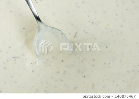 Spoonful of creamy tartar sauce over the bowl, copy space for text Spoonful of creamy tartar sauce over the bowl, copy space for text 140873467