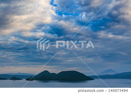 Dynamic clouds and majestic mountain ranges envelop Lake Toya, a caldera lake representative of Hokkaido. Dynamic clouds and majestic mountain ranges envelop Lake Toya, a caldera lake representative of Hokkaido. 140873494
