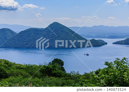 乘坐直升機從空中俯瞰洞爺湖，這座火山口湖被豐富的自然資源所環繞，景色令人嘆為觀止。 140873524