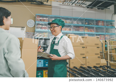超市後倉工作人員面帶微笑地處理貨物。 超市後倉工作人員面帶微笑地處理貨物。 140873992