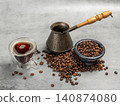 Cup of coffee, a cezve and a stone bowl with roasted coffee beans. 140874080