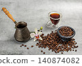 Cezve, a cup of coffee and a stone bowl with roasted coffee beans. 140874082