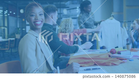 Smiling woman in beige blazer taking notes at meeting table with garment rack, copy space Smiling woman in beige blazer taking notes at meeting table with garment rack, copy space 140875086