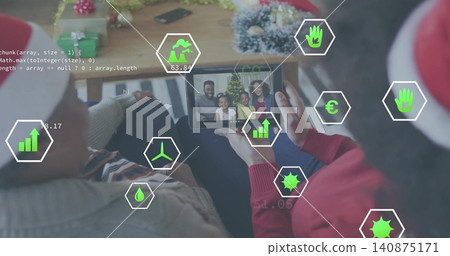 Holding couple wearing holiday hats leaning on couch, viewing tablet with family portrait overlays Holding couple wearing holiday hats leaning on couch, viewing tablet with family portrait overlays 140875171