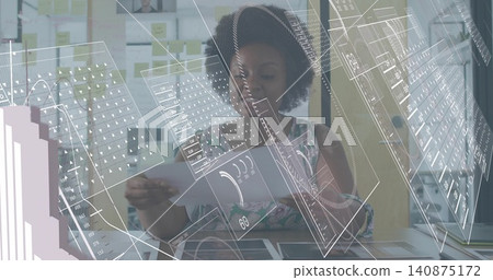 Reading woman in patterned top holding printed layouts at desk, viewing holographic UI overlays Reading woman in patterned top holding printed layouts at desk, viewing holographic UI overlays 140875172