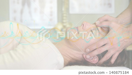 Receiving patient wearing light top with therapist hands cradling head in clinic, waveform overlay Receiving patient wearing light top with therapist hands cradling head in clinic, waveform overlay 140875184