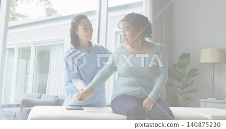 Supporting caregiver in blue scrubs guiding senior in blue top on padded bench at home, smartphone Supporting caregiver in blue scrubs guiding senior in blue top on padded bench at home, smartphone 140875230