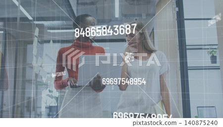 Walking two women in glass office hall, workwear, checking silver laptop, yellow file, AR overlay Walking two women in glass office hall, workwear, checking silver laptop, yellow file, AR overlay 140875240