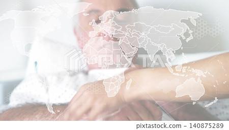 Holding short-sleeve woman's forearm, helping senior male lying on bed with gown, world map overlay Holding short-sleeve woman's forearm, helping senior male lying on bed with gown, world map overlay 140875289