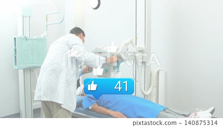 Adjusting tech in labcoat leaning over patient in blue gown, aiming xray tube above chest, bubble41 Adjusting tech in labcoat leaning over patient in blue gown, aiming xray tube above chest, bubble41 140875314