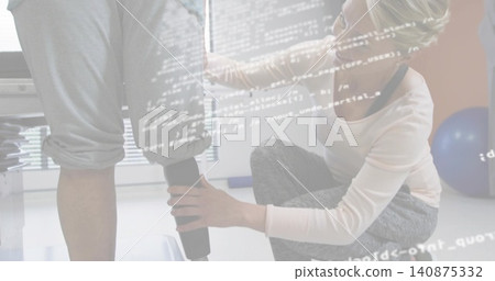 Adjusting kneeling therapist fitting prosthetic leg on patient in clinic, wearing gray leggings Adjusting kneeling therapist fitting prosthetic leg on patient in clinic, wearing gray leggings 140875332