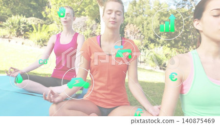 Meditating central woman wearing orange tee with companions on park lawn, yoga mats and green icons Meditating central woman wearing orange tee with companions on park lawn, yoga mats and green icons 140875469