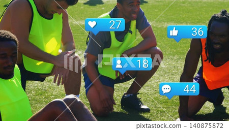 Gathering four soccer players wearing neon pinnies and cleats, resting on grass with blue badges Gathering four soccer players wearing neon pinnies and cleats, resting on grass with blue badges 140875872