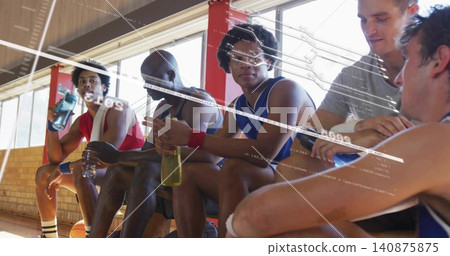 Sitting six basketball players in jerseys on wooden bench gym sideline, holding bottles and ball Sitting six basketball players in jerseys on wooden bench gym sideline, holding bottles and ball 140875875