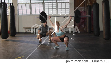 Performing female athlete squatting with barbell at gym in sportswear, trainer spotting Performing female athlete squatting with barbell at gym in sportswear, trainer spotting 140875955