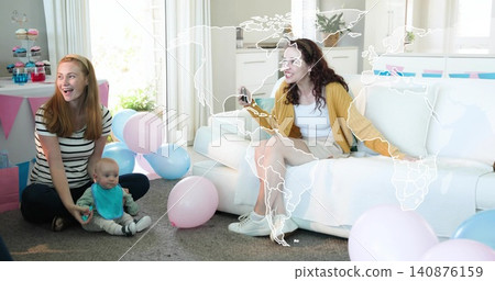 Supporting infant in living room, woman in striped top holding baby, woman with phone, cupcakes 140876159