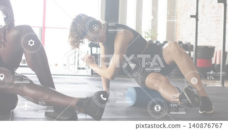 Rolling female athlete wearing dark bra matching shorts using foam-roller on gym floor, AR overlays Rolling female athlete wearing dark bra matching shorts using foam-roller on gym floor, AR overlays 140876767