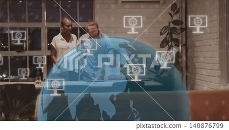 Collaborating team leaning over woman in white sleeveless top using tablet in office with globe Collaborating team leaning over woman in white sleeveless top using tablet in office with globe 140876799