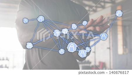 Extending man wearing dark fitted shirt holding forearms forward at gym, showing AR network overlay Extending man wearing dark fitted shirt holding forearms forward at gym, showing AR network overlay 140876817