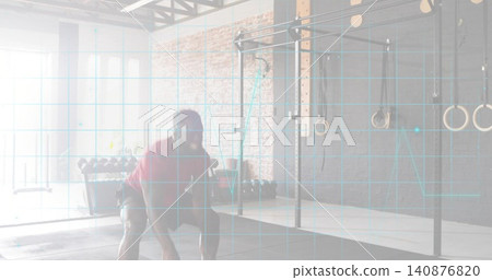 Reaching man wearing red T-shirt bending into low squat grabbing weight on gym floor, ECG overlay 140876820