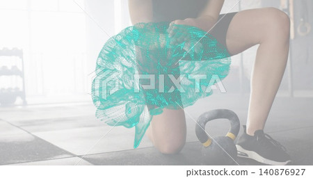 Kneeling woman wearing shorts and sneakers presenting teal 3D brain mesh on gym floor, kettlebell Kneeling woman wearing shorts and sneakers presenting teal 3D brain mesh on gym floor, kettlebell 140876927