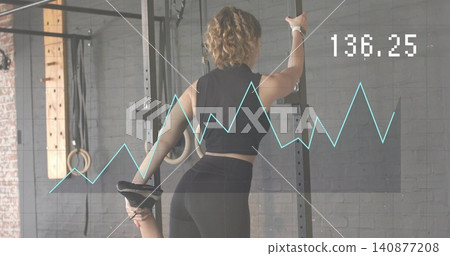 Holding rack, woman in black activewear pulling foot to glutes in gym, with digital 136 Holding rack, woman in black activewear pulling foot to glutes in gym, with digital 136 140877208