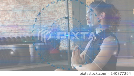 Sitting woman in black tank top pressing palms in studio with weights, blue HUD, copy space Sitting woman in black tank top pressing palms in studio with weights, blue HUD, copy space 140877294