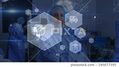 Standing clinician in blue scrubs, mask lowered crossing arms, facing in OR, with hex HUD overlay Standing clinician in blue scrubs, mask lowered crossing arms, facing in OR, with hex HUD overlay 140877395