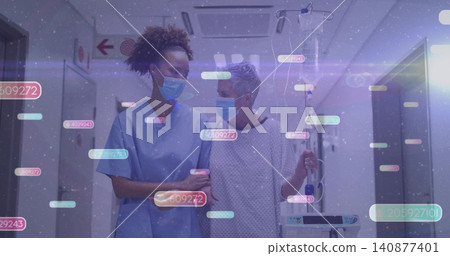 Walking nurse in blue scrubs supporting patient in hospital hall holding IV pump masks digital tags Walking nurse in blue scrubs supporting patient in hospital hall holding IV pump masks digital tags 140877401