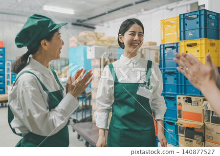 後屋裡,女員工們面帶微笑,鼓掌歡呼。 後屋裡,女員工們面帶微笑,鼓掌歡呼。 140877527