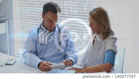 Reviewing doctor wearing blue shirt and patient reading blood pressure cuff and monitor at clinic Reviewing doctor wearing blue shirt and patient reading blood pressure cuff and monitor at clinic 140877597