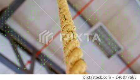 Hanging thick twisted natural rope running upward at gym ceiling, showing beams, binary overlay Hanging thick twisted natural rope running upward at gym ceiling, showing beams, binary overlay 140877665