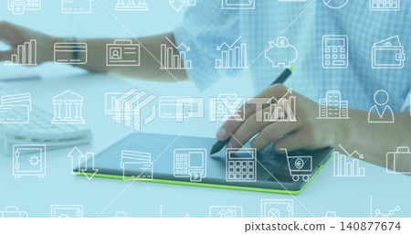 Working man wearing blue checkered shirt using stylus on graphics tablet at desk with finance icons Working man wearing blue checkered shirt using stylus on graphics tablet at desk with finance icons 140877674