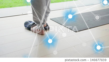 Slipping older man's foot into plaid slipper by glass door, wearing gray sweats, mat, copy space Slipping older man's foot into plaid slipper by glass door, wearing gray sweats, mat, copy space 140877839