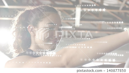Stretching woman reaching forward at gym, wearing dark tank, with beams, ceiling light, star flares Stretching woman reaching forward at gym, wearing dark tank, with beams, ceiling light, star flares 140877850