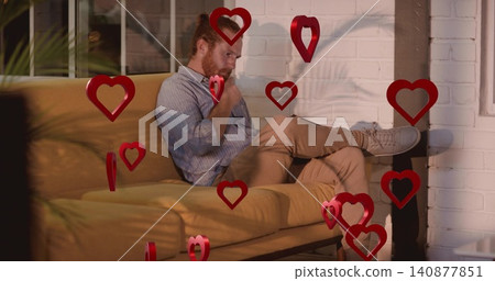 Sitting red-haired man crossing leg and gazing in loft, with mustard sofa, floating red hearts Sitting red-haired man crossing leg and gazing in loft, with mustard sofa, floating red hearts 140877851