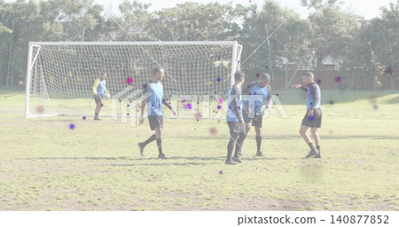 Practicing five players and goalkeeper wearing blue and yellow vests on grass pitch with white goal Practicing five players and goalkeeper wearing blue and yellow vests on grass pitch with white goal 140877852