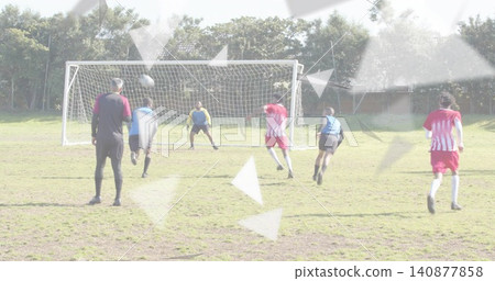 Contesting soccer players in striped kits and blue bibs defending goal on worn pitch, ball airborne Contesting soccer players in striped kits and blue bibs defending goal on worn pitch, ball airborne 140877858
