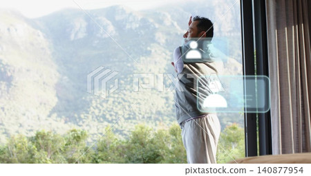 Standing Asian man reaching window in suite, in lounge pants and vest, holographic UI, copy space Standing Asian man reaching window in suite, in lounge pants and vest, holographic UI, copy space 140877954