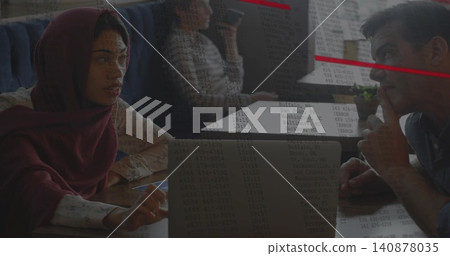 Gesturing woman in maroon scarf leading meeting at wood table, laptop with data overlay, copy space Gesturing woman in maroon scarf leading meeting at wood table, laptop with data overlay, copy space 140878035