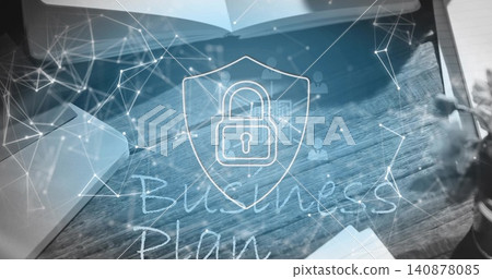 Displaying central shield padlock graphic over wood desk, showing laptop, notebook, papers, plant Displaying central shield padlock graphic over wood desk, showing laptop, notebook, papers, plant 140878085