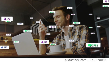 Scrolling man wearing plaid shirt tapping phone at cafe table, with laptop, coffee, notifications Scrolling man wearing plaid shirt tapping phone at cafe table, with laptop, coffee, notifications 140878096