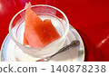 A juicy watermelon in a glass container on a red table. 140878238