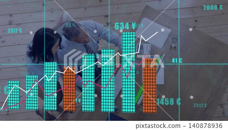 Reviewing colleagues in business attire at office table with laptop and financial overlay 140878936