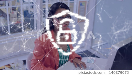 Typing Asian woman wearing coral blazer and glasses at office desk with keyboard and glowing symbol Typing Asian woman wearing coral blazer and glasses at office desk with keyboard and glowing symbol 140879073