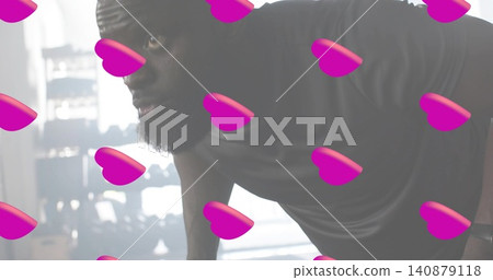 Performing man leaning forward in gym, showing dark T-shirt, wristband and pink heart overlays Performing man leaning forward in gym, showing dark T-shirt, wristband and pink heart overlays 140879118