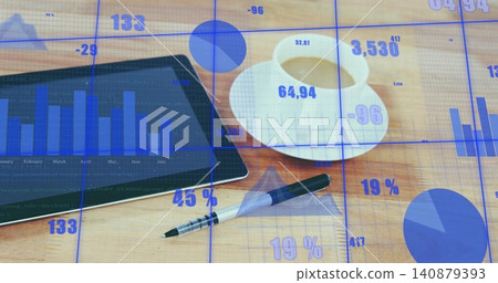 Displaying tablet with bar chart and financial overlays on wooden desk, white coffee cup and pen 140879393