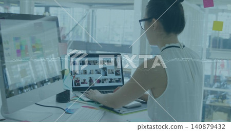 Editing woman in sleeveless top reviewing laptop grid in office, monitor charts, copy space Editing woman in sleeveless top reviewing laptop grid in office, monitor charts, copy space 140879432
